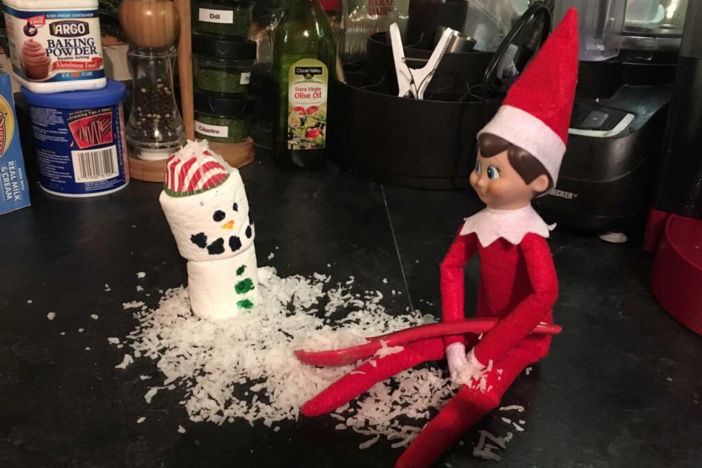 Elf making snowman with marshmallows.