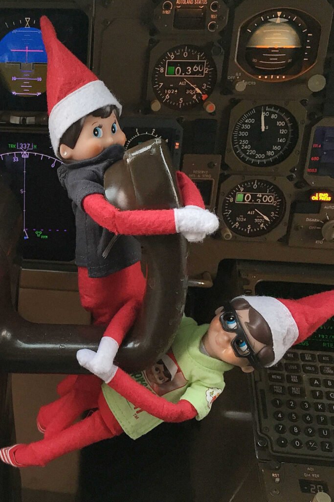 Elf on the shelf in plane cockpit.
