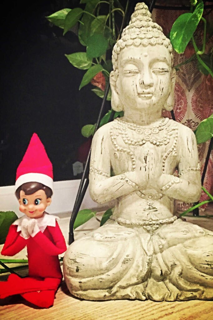 Christmas Elf posing with Buddha.