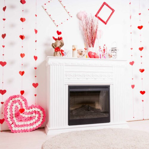 Fireplace with Valentine decorations around the mantle and around the fireplace.