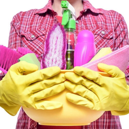 Lady with arms full of cleaning supplies.